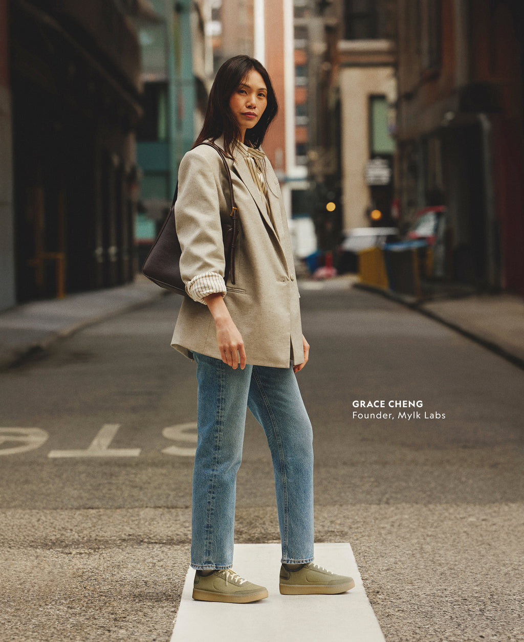 Grace Cheng, Founder of Mylk Labs, wearing a beige blazer and jeans styled with green Allbirds Varsity Cruiser sneakers.